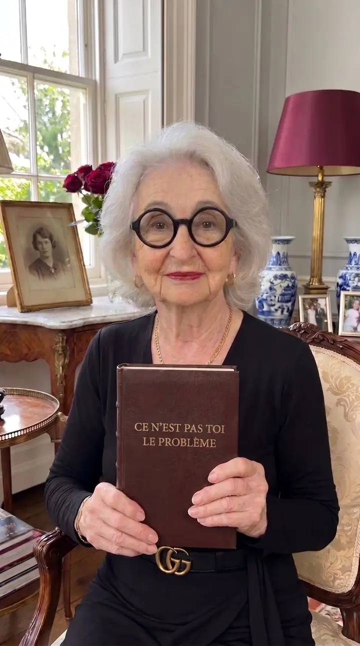 Colette, 89 ans, tenant son livre à la main